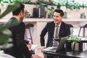Grupo de empresarios diversos que crean un exitoso trabajo en equipo mientras trabajan juntos con una computadora portátil.