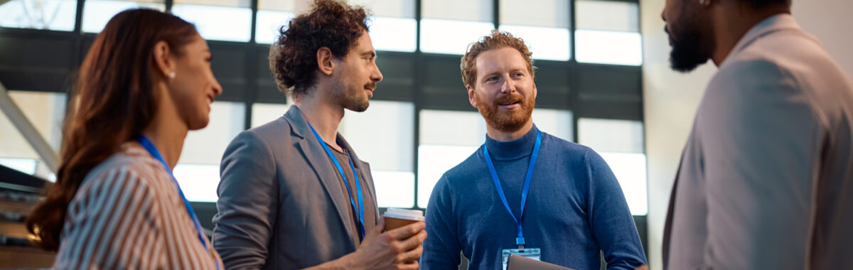 networking-monterrey-2 Conversación casual entre colegas en Networking Monterrey, mientras tienen un café en mano, gafetes visibles y ambiente relajado.