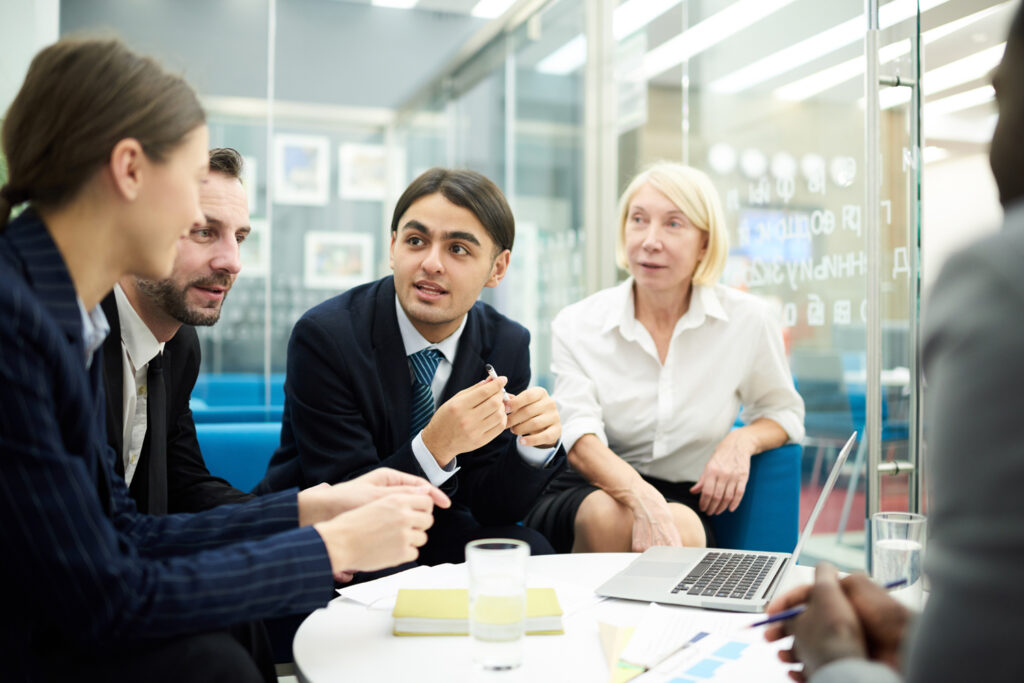 Grupo de personas en un ambiente colaborativo discute ideas frente a laptop en el Small Business Development Center