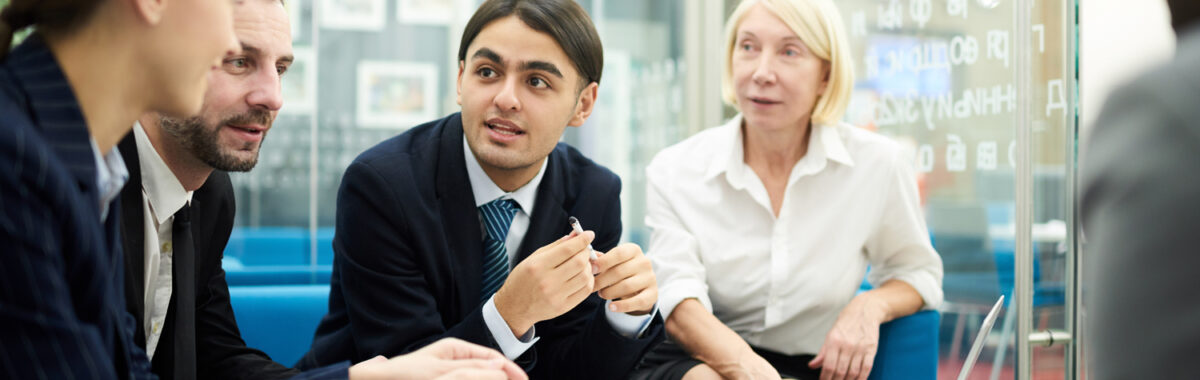 small-business-development-center-3 Grupo de personas en un ambiente colaborativo discute ideas frente a laptop en el Small Business Development Center