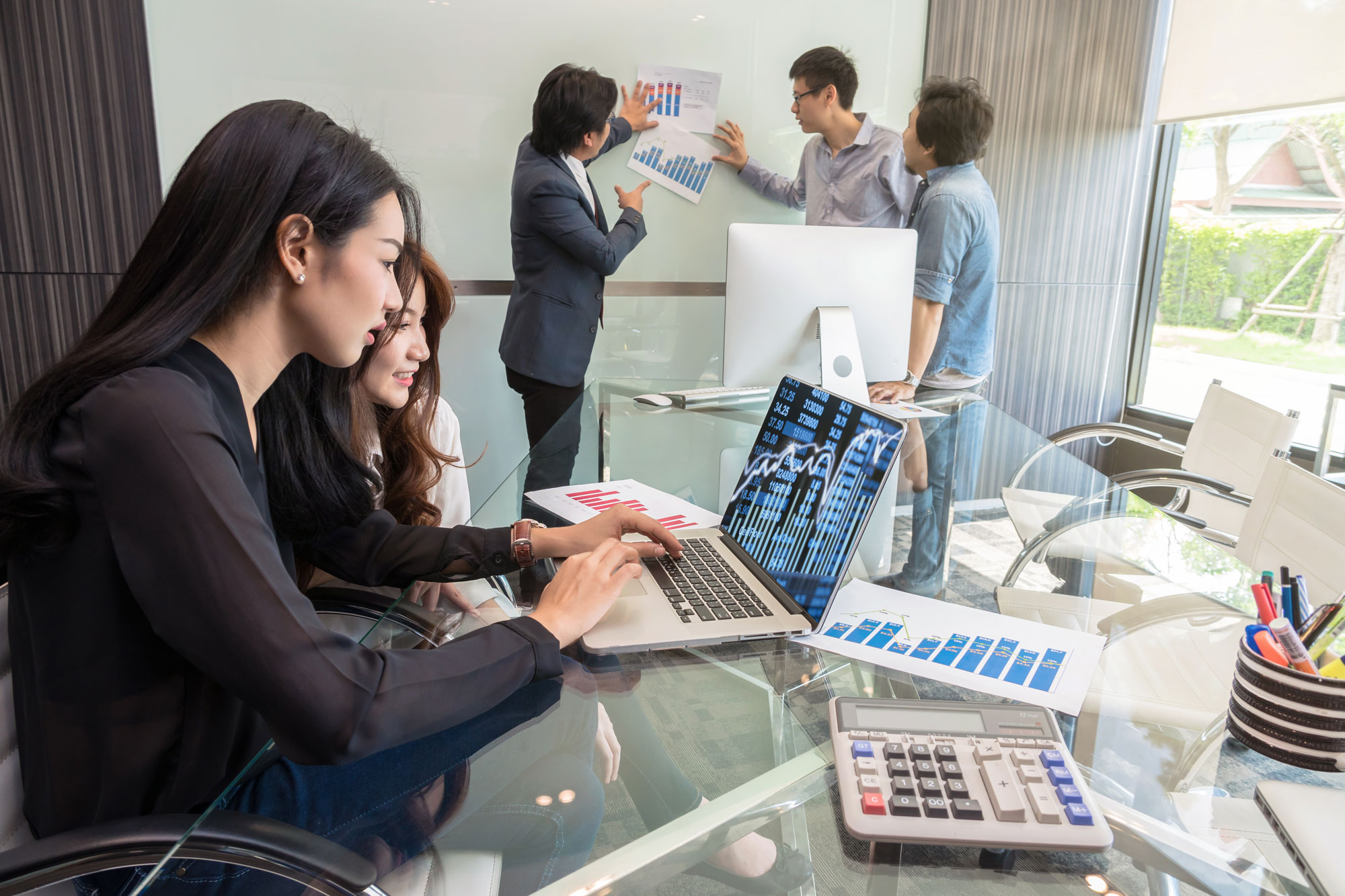 desarrollo-de-pymes-monterrey-2 Una reunión de equipo se enfoca en el análisis de gráficos financieros y estrategias, representando iniciativas clave para el desarrollo de pymes Monterrey.
