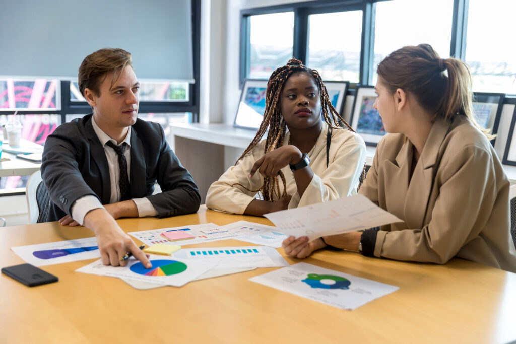 Consultoría empresarial dentro de una oficina, se proporciona a un grupo de empleados Un grupo de empleados está alrededor de una mesa en una oficina y toman una consultoría empresarial