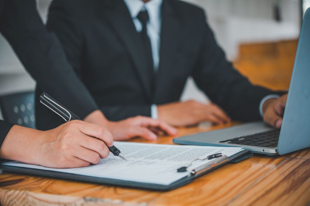 Firma de papeles por dos personas, son trámites para iniciar un negocio en México Se están checando trámites para iniciar un negocio en México, dos personas firman papeles