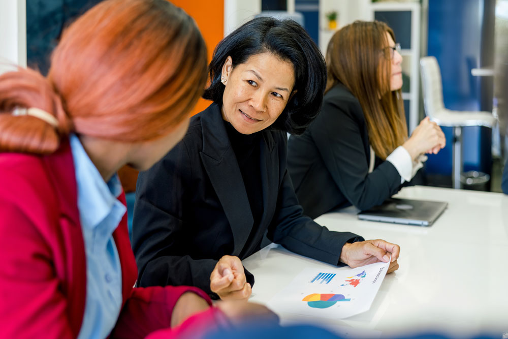 En una oficina hay una mujer que está impartiendo una capacitación empresarial al personal Capacitación empresarial al personal de una empresa, una mujer la está impartiendo en una oficina
