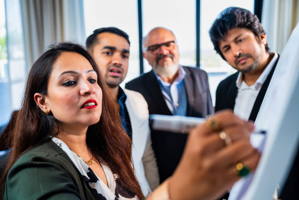 Hay un equipo de trabajo que está escribiendo en un pizarrón, es la importancia de las Pymes en México