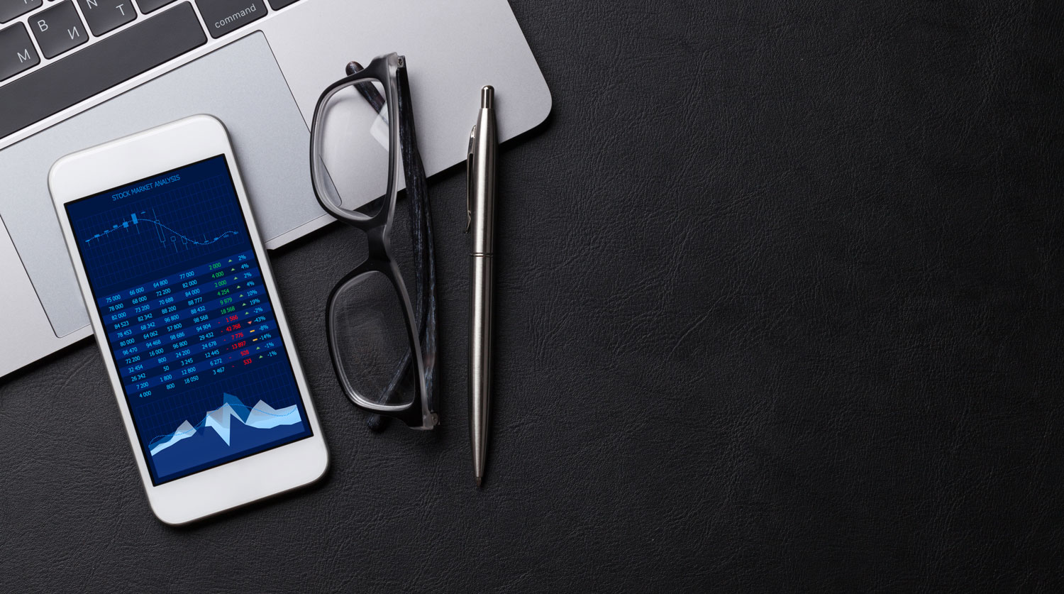 Digitalización de procesos PYMES, hay un celular y una computadora sobre una mesa