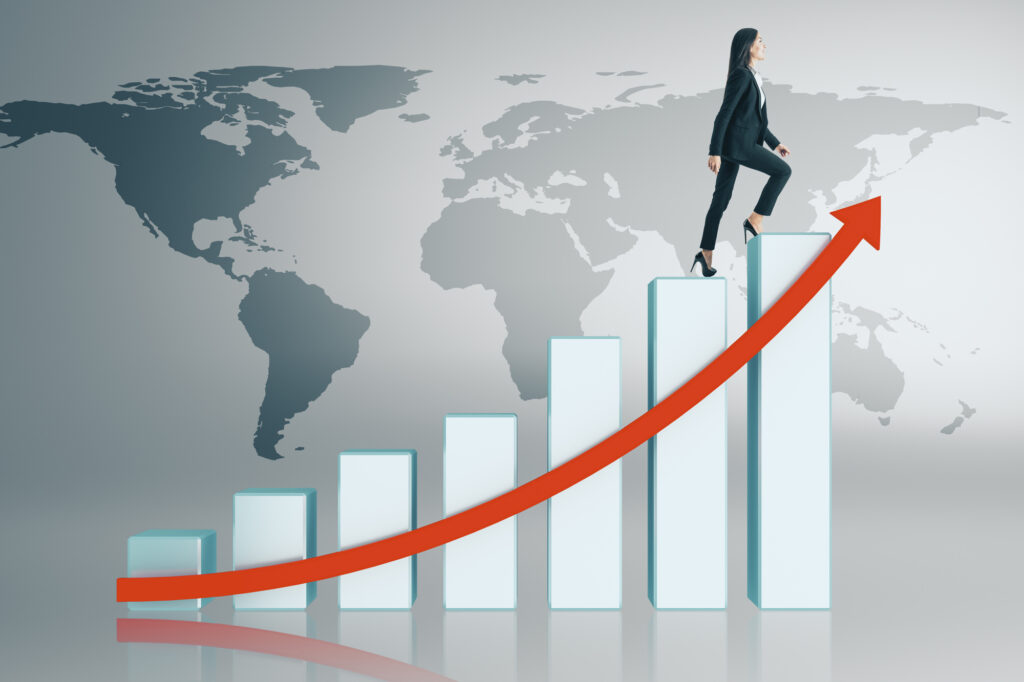 Mujer de negocios subiendo gráfica con flecha roja sobre mapa mundial, mostrando cómo hacer crecer una empresa globalmente