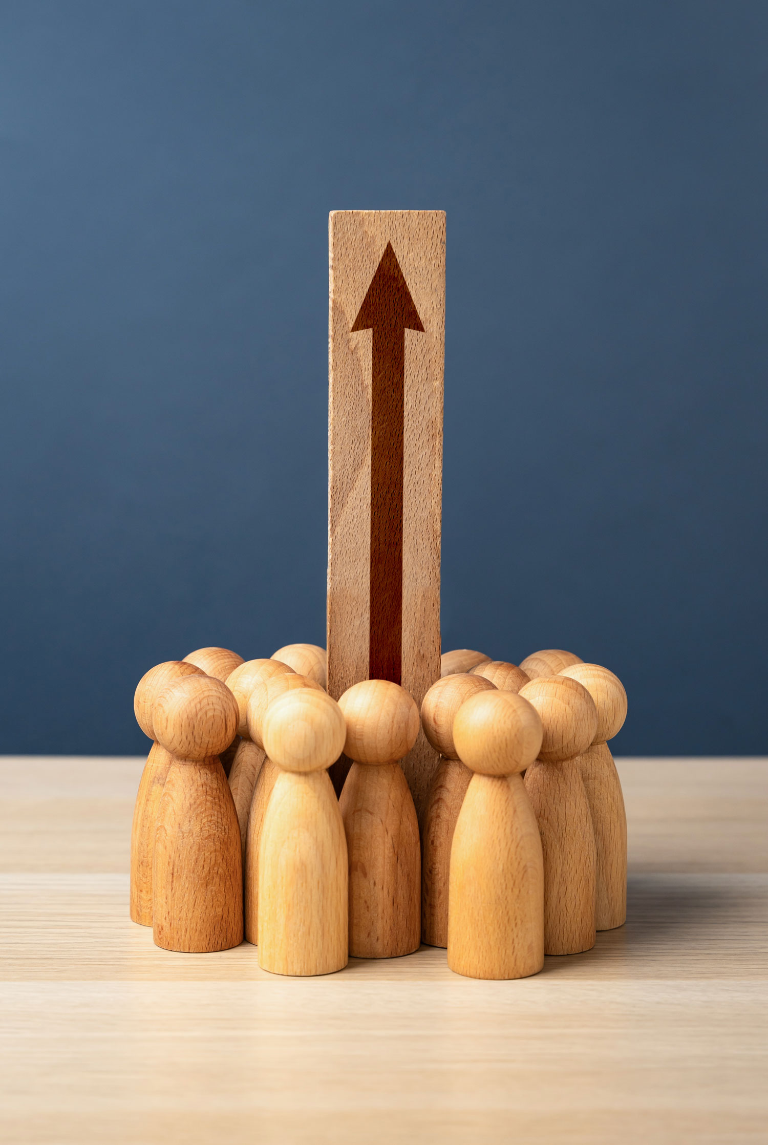 Estrategia liderazgo como hacer crecer una empresa Figuras de madera agrupadas con una flecha ascendente que ilustra cómo hacer crecer una empresa mediante el liderazgo