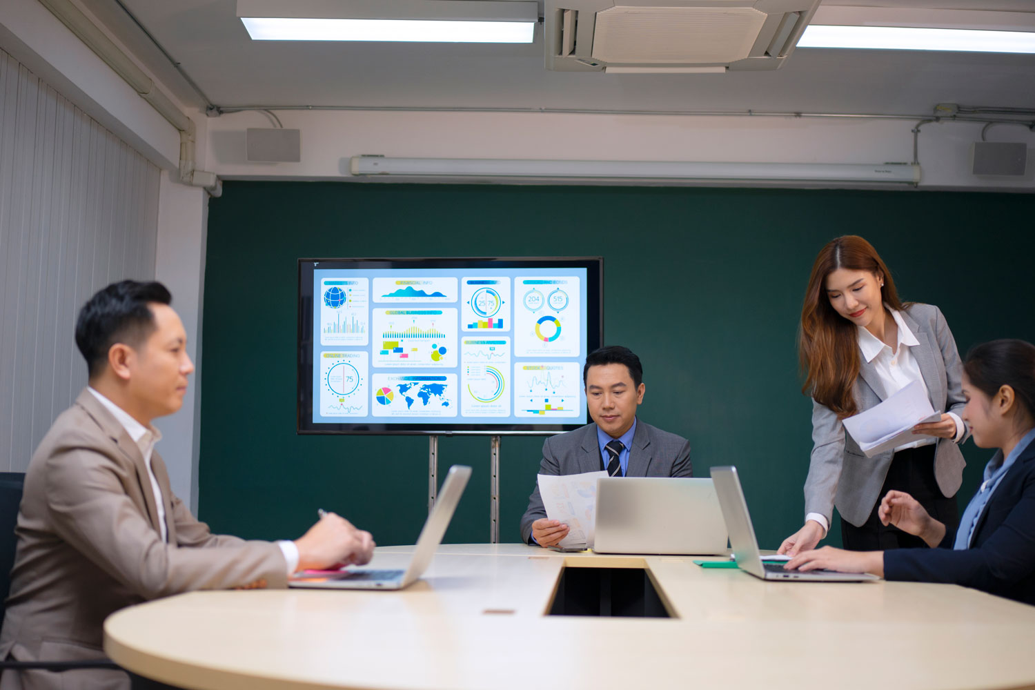 Estrategias colaborativas para la eficiencia operativa Equipo de trabajo analizando métricas en una pantalla digital para mejorar la eficiencia operativa en su reunión diaria.