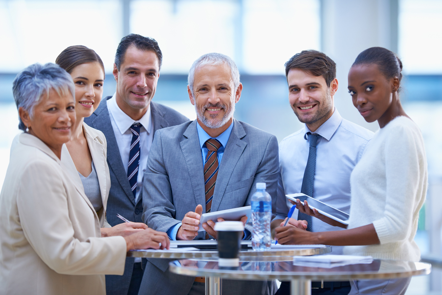 Grupo diverso de directivos trabajando juntos, ejemplo de liderazgo empresarial participativo.