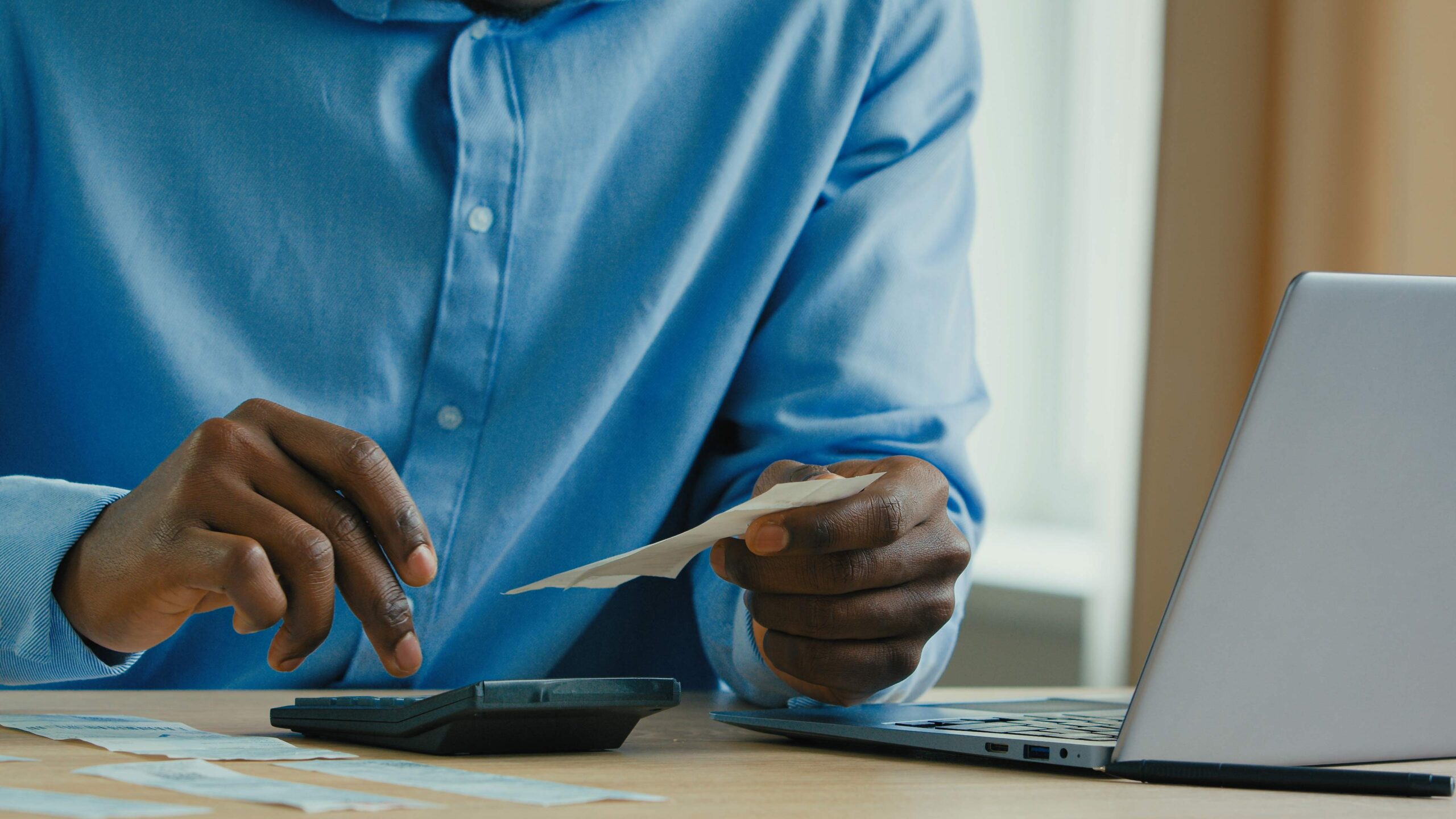 Hombre de negocios usando calculadora para sumar recibos y poder facturar sin ser autónomo los gastos