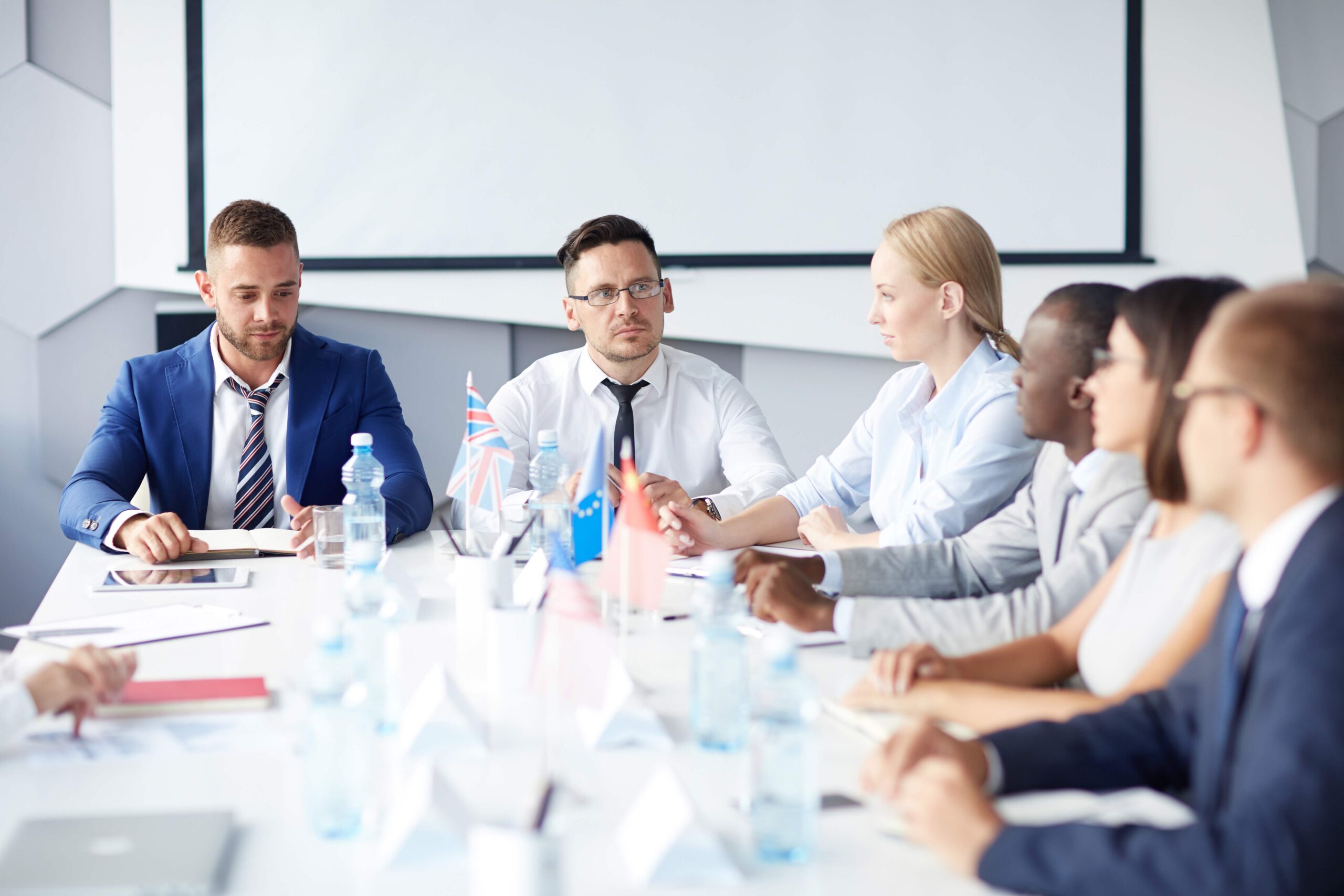 Estrategia y planificación global sobre cómo iniciar una PYME Socios en una mesa de juntas discutiendo estrategias internacionales y consejos sobre como iniciar una pyme competitiva.
