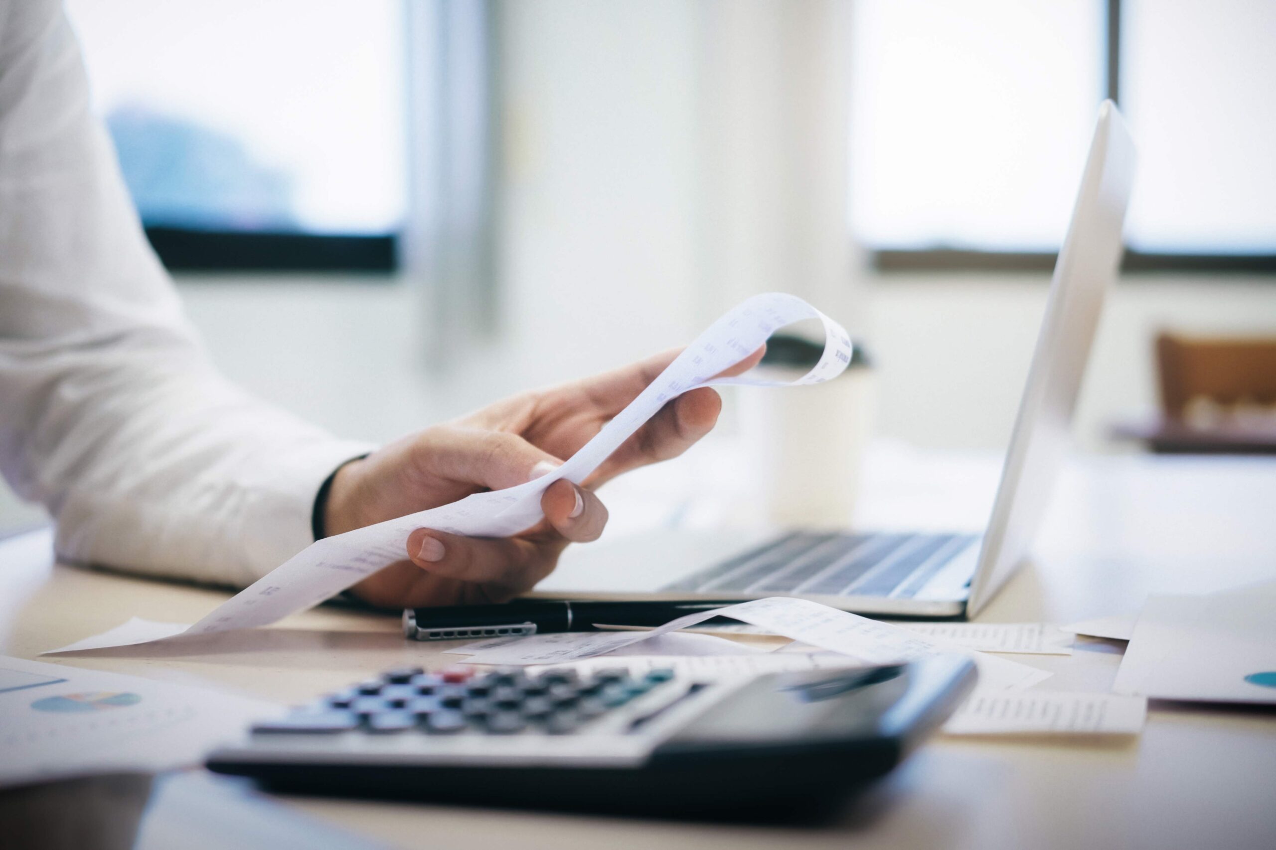 Empleado de contabilidad revisando tickets y recibos para facturar gastos operativos de la empresa correctamente.