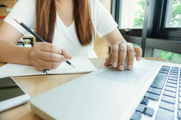 Emprendedora firmando documentos legales y formularios sobre cómo registrar mi negocio ante las autoridades.