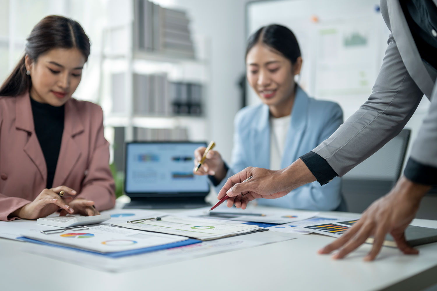 Consultoría y optimización de la Administración financiera en empresas Equipo de trabajo revisando reportes y gráficos impresos para mejorar la administración financiera de su organización.