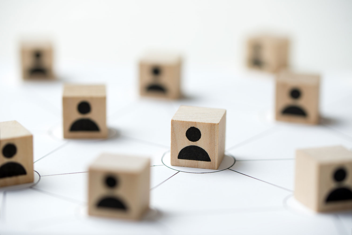 Redes de Negocio: La Base de la Colaboración Digital Cubos de madera con iconos de personas unidos por líneas finas, simbolizando redes de negocio sólidas y modulares
