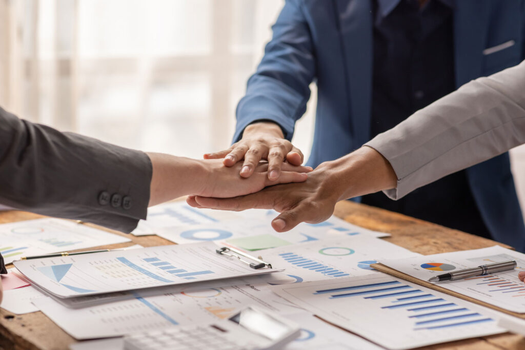 Equipo de consultores uniendo manos tras definir los criterios estratégicos de cómo se valúa una empresa con éxito