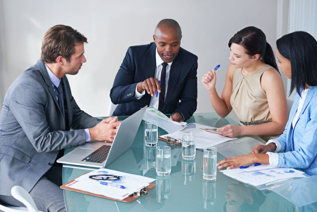 Equipo ejecutivo analizando resultados de consultoría para pymes sobre una mesa de cristal en reunión