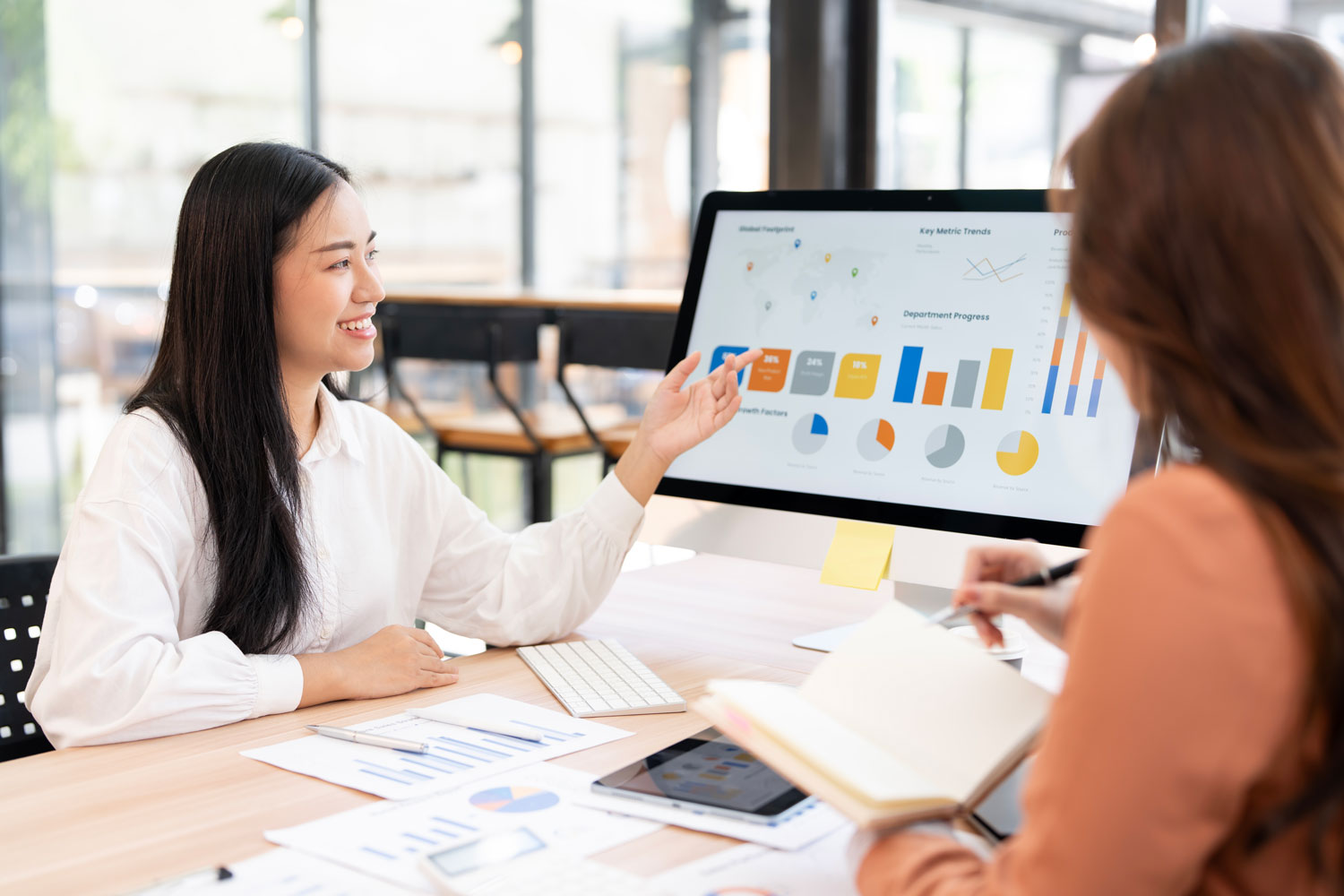 Herramientas tecnológicas para la Administración financiera moderna Dos profesionales analizando métricas y dashboards digitales de administración financiera en un monitor moderno