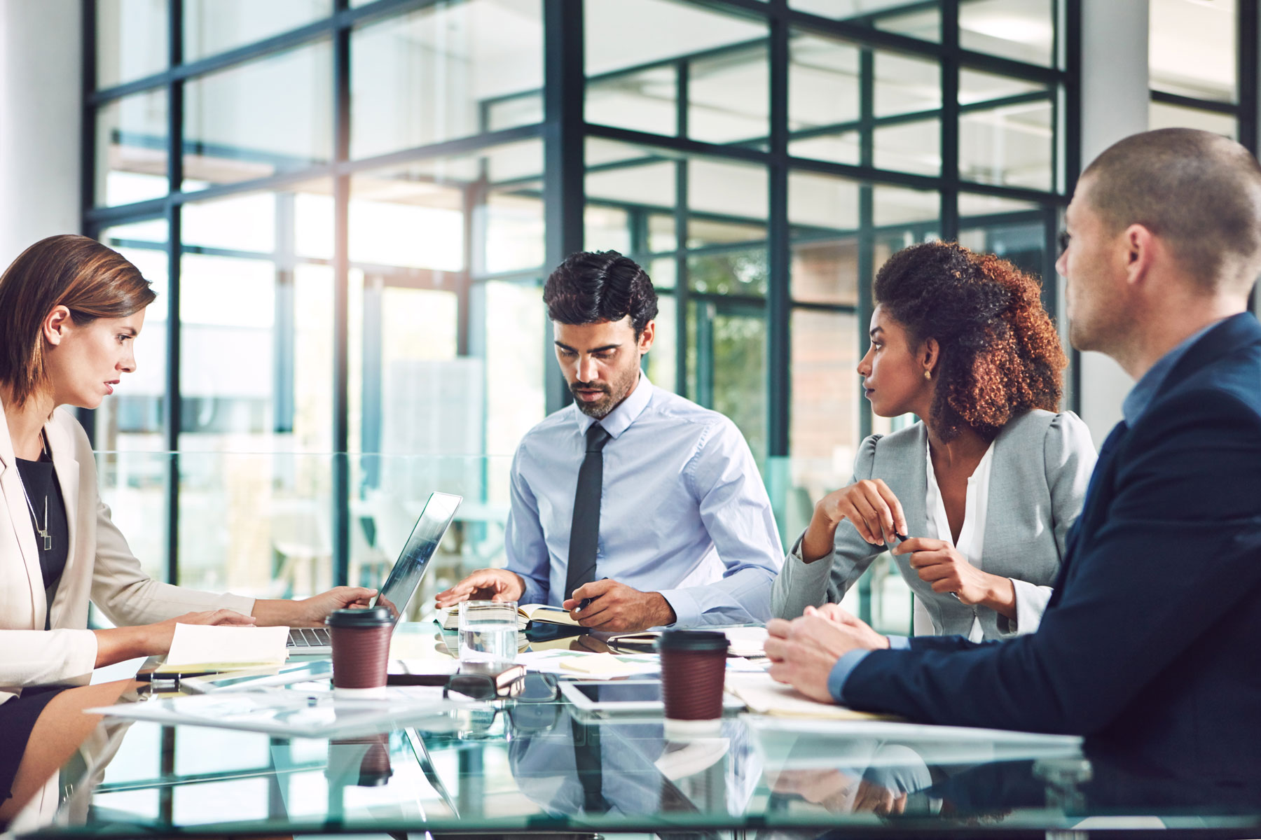 Socios discutiendo el estado actual del flujo de caja cash flow de la empresa Profesionales de negocios discutiendo estrategias financieras y el estado del flujo de caja cash flow alrededor de una mesa