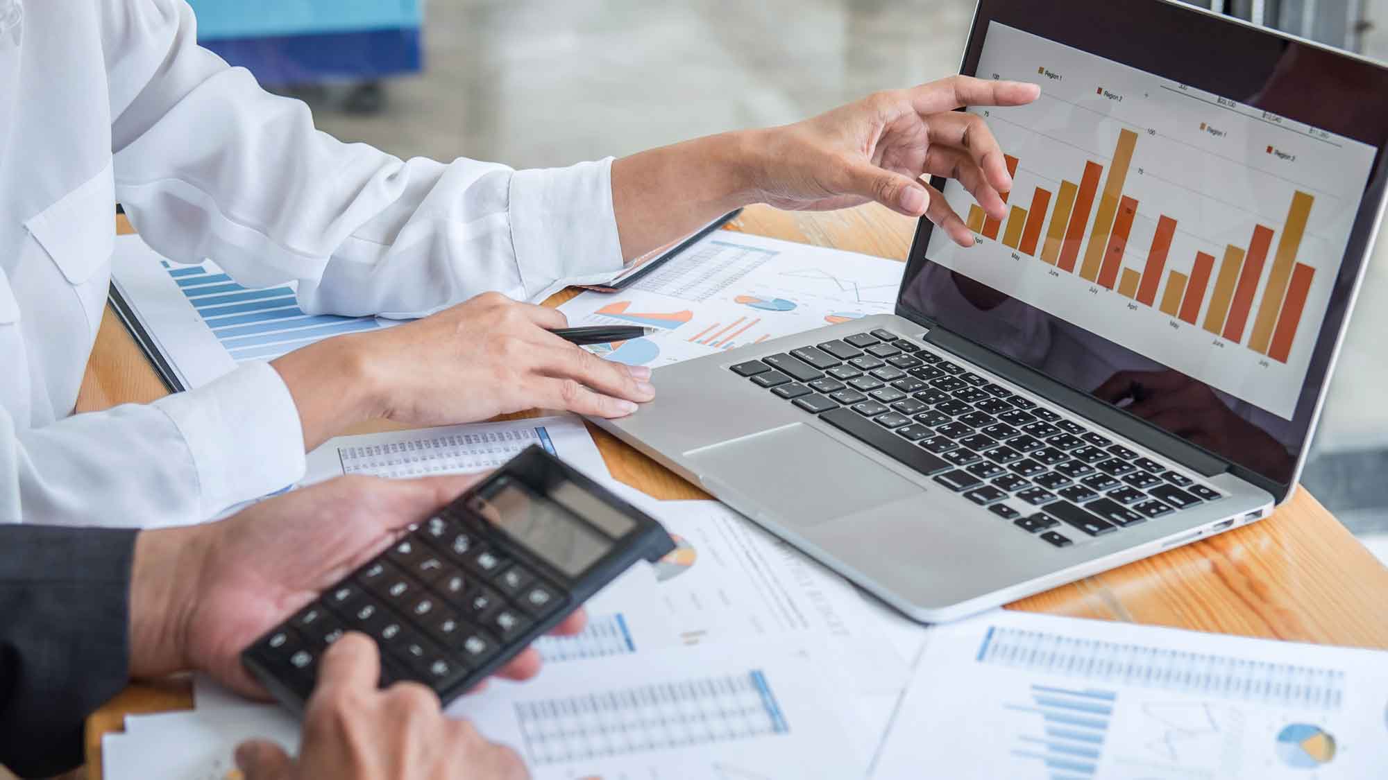 Evaluación de rendimiento financiero para un MVP Producto mínimo viable Especialistas analizan gráficas en laptop para medir la rentabilidad de un MVP Producto mínimo viable en el mercado